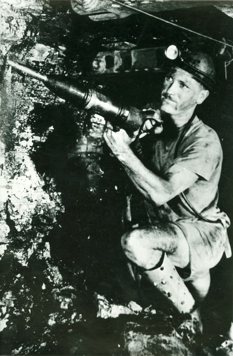 Een mijnwerker boort een ondergrondse steenkoollaag aan